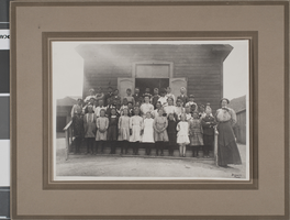 Photograph of children with their teacher outside of a schoolhouse in Tonopah, Nevada, circa 1909