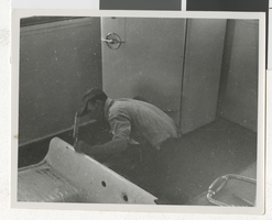 Photograph of unidentified man renovating old barracks, Boulder City (Nev.), 1953