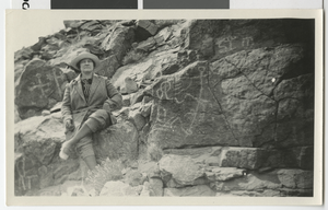 Photograph of Nellie Waite in front of petroglyphs, 1910s