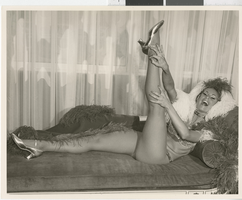 Photograph of Minsky's showgirl posing on a sofa at the Playboy Hotel, Chicago (Ill.), circa 1977