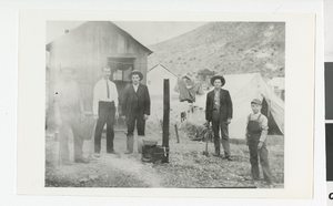 Photograph of people standing around an outdoor stove, Rhyolite (Nev.), 1910-1920