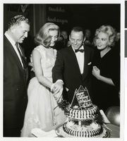 Photograph of Lauren Bacall cutting her birthday cake with the help of Frank Sinatra, Sands Hotel, Las Vegas, circa 1950s