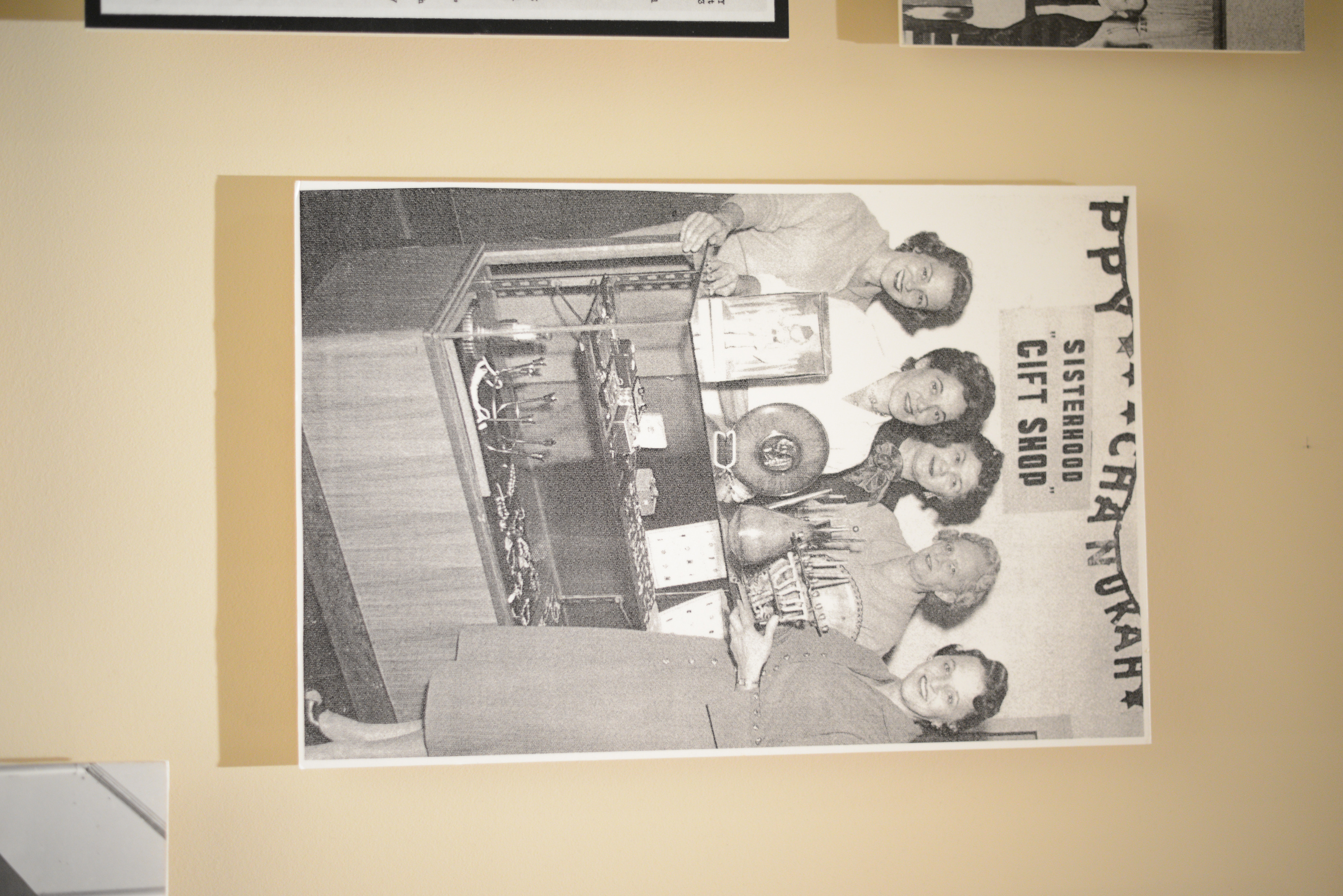 Photograph of women gathered around a merchandise display for the Sisterhood gift shop