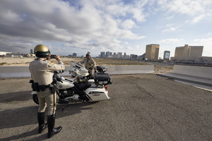 Metro Police officers taking photo with Las Vegas Stadium site pre-construction, Las Vegas, Nevada: digital photograph