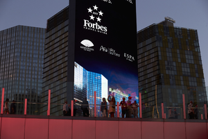 Tourists silhouetted against electronic board on the Strip, Las Vegas, Nevada: digital photograph