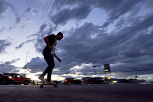 Skateboarder on East Sahara Avenue and Eastern Avenue looking west at sunset, Las Vegas, Nevada: digital photograph