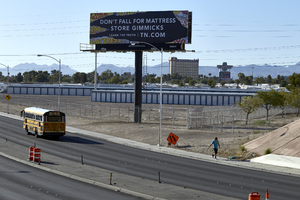 Bus and pedestrian on East Sahara Avenue and the US 95 freeway overpass looking east with billboard and Boulder Station, Las Vegas, Nevada: digital photograph