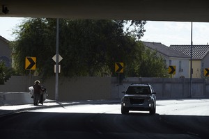 Homeless man and car use the freeway overpass at East Sahara Avenue and Sandhill Road looking east, Las Vegas, Nevada: digital photograph