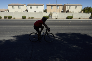 Bicyclist and single family housing along East Sahara Avenue west of Tree Line Drive, looking north, Las Vegas, Nevada: digital photograph