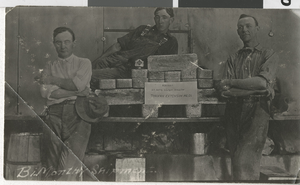 Three individuals pose with 25 silver bullion bars worth $32,000 for the Tonopah Extension Mining Company bi-monthly shipment: photographic print