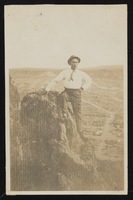 Worker posing by a rock: photographic print