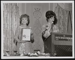 Judy Bayley accepting honroary proclamation for "Judy Bayley Day" from an unidentified woman: photographic print