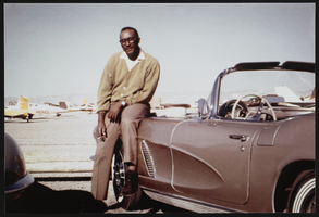 James B. McMillan posing by his sports car: photographic print