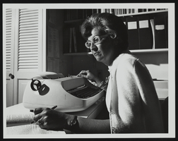 Jean Ford working at her typewriter: photographic print