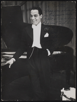 Unidentified performer standing next to a piano: photographic print