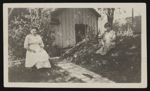 Two women sitting on a law: photographic print
