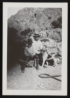 Mr. Margier and Ralph sitting with the dog Bologny in front of desert landscape: photographic print