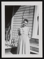 Woman posed in front of a house: photographic print