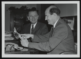 Howard Cannon congratulates Lee Walker, a member of Cannon's staff, for receiving a Master's degree from George Washington University: photographic print