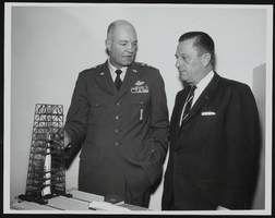 Howard Cannon and Lieutenant General Howell M. Estes discuss an Atlas-Agena space launching facility model: photographic print