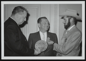Howard Cannon being presented a Las Vegas Elks Helldorado button by two unidentified men: photographic print