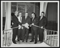 Howard Cannon cuts ribbon at an opening with E. Parry Thomas, W. W. Galloway, and two unidentified men: photographic print