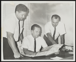 Howard Cannon and two unidentified men at desk looking over a map of Lake Mead: photographic print