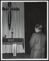 Howard Cannon praying before a cross at an event: photographic print