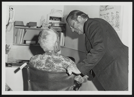 Howard Cannon speaking to an elderly man in a wheelchair: photographic print