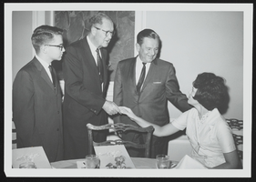 Howard Cannon speaking with three unidentified people: photographic print