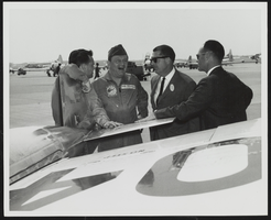 Howard Cannon on an airfield next to an aircraft speaking to three unidentified men, one is an F-104 Starfighter pilot: photographic print