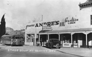 Postcard showing a bus stopped at Andre's Grocery Store and Fountain near the Exchange Hotel, Main Street, Beatty, Nevada: photographic print