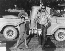 Bob Ruud and his youngest son, Robin, in front of Frank Woner's house: photographic print