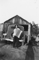 Irene Nelly Boni playing the accordion in front of the garage: photographic print