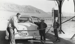 Man putting gas in automobile: photographic print