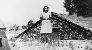 Shirley Ann Berg (Lofthouse) pictured in front of the bottle cellar constructed next to the family home by her father in Round Mountain, Nevada: photographic print