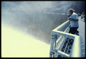 A man watches water flowing down the Arizona spillway, looking northeast at Hoover Dam, Arizona: photographic slide