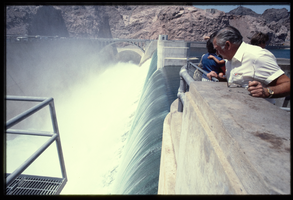 A man watches water flowing down the Arizona spillway, looking south at Hoover Dam, Arizona: photographic slide