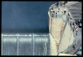 People line the observation platform along the Arizona spillway to watch overflow water, looking west at Hoover Dam, Arizona: photographic slide
