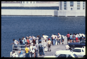 People line the observation platform along the Arizona spillway as seen with the intake towers in the background, looking west at Hoover Dam, Arizona: photographic slide