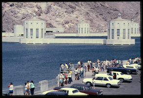 People line the observation platform along the Arizona spillway as seen with the intake towers in the background, looking west at Hoover Dam, Arizona: photographic slide