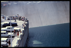 People along the observation deck watch water spill over the Arizona spillway, looking southeast at Hoover Dam, Arizona: photographic slide