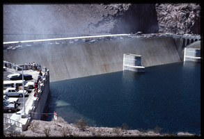 People along the observation deck watch water spill over the Arizona spillway, looking southeast at Hoover Dam, Arizona: photographic slide
