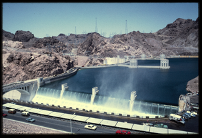 Water crashes over the Arizona spillway from a filled Lake Mead basin as seen from a lookout above the dam, looking west towards the Nevada side at Hoover Dam, Arizona: photographic slide