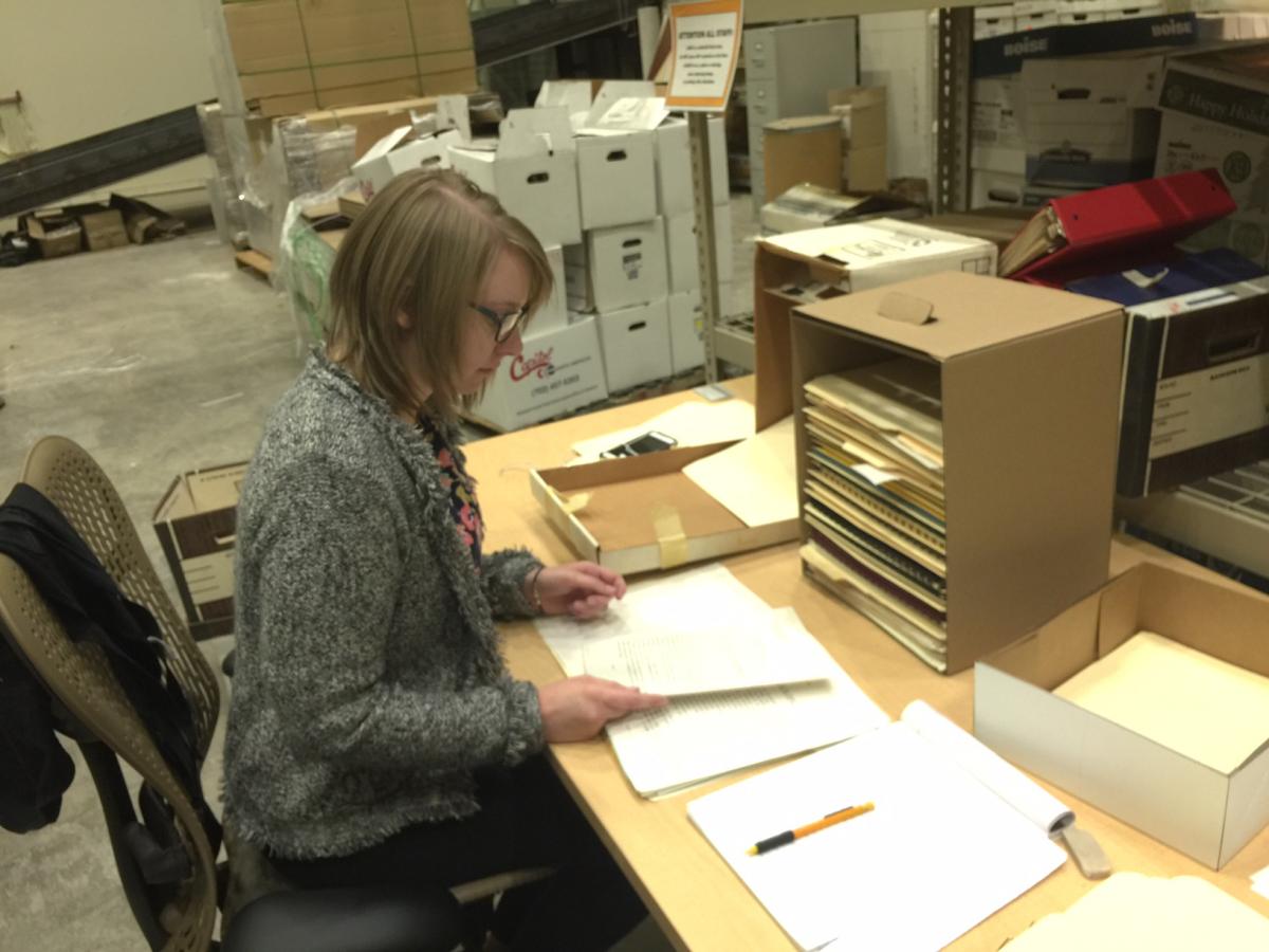 An archivist looks through papers and documents.