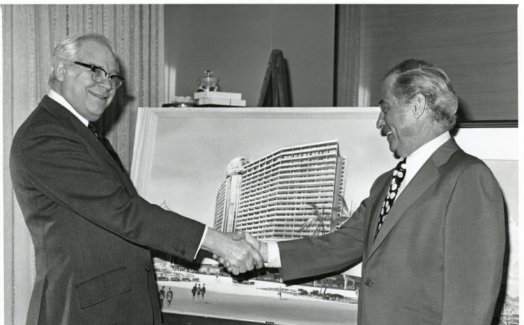 Morris Shenker, left, shaking hands with an unidentified man in front of an architectural drawing for the Dunes Hotel and Casino in Las Vegas, Nevada, circa 1950s