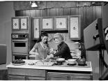Muriel Stevens cooking with a guest on her tv show, circa 1975