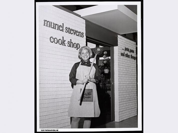 Muriel Stevens in front of her cook shop, circa 1975