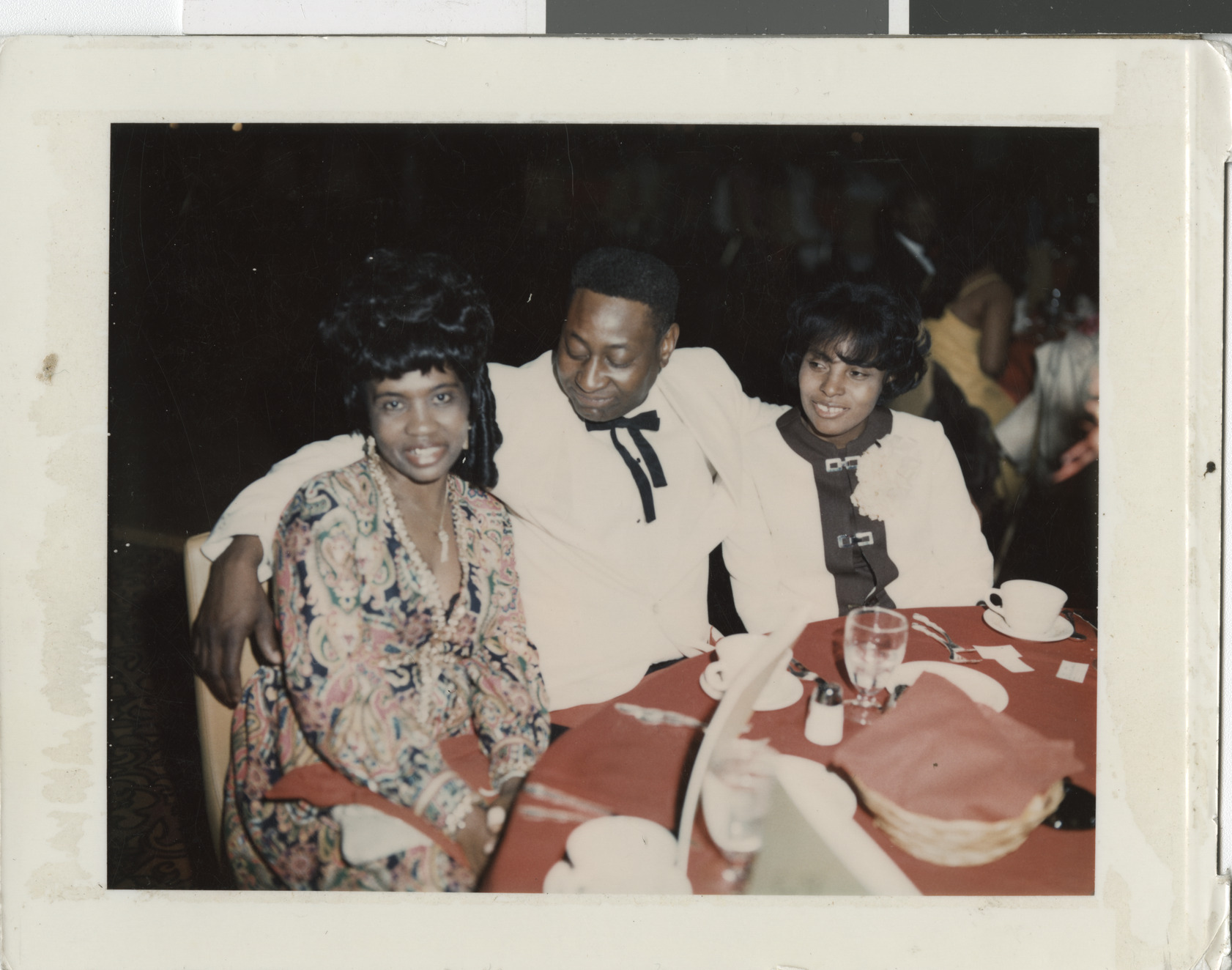 Color polaroid photograph mounted on board of Sweetie , Coye King and Ruby (right) at the Moulin Rouge, no date