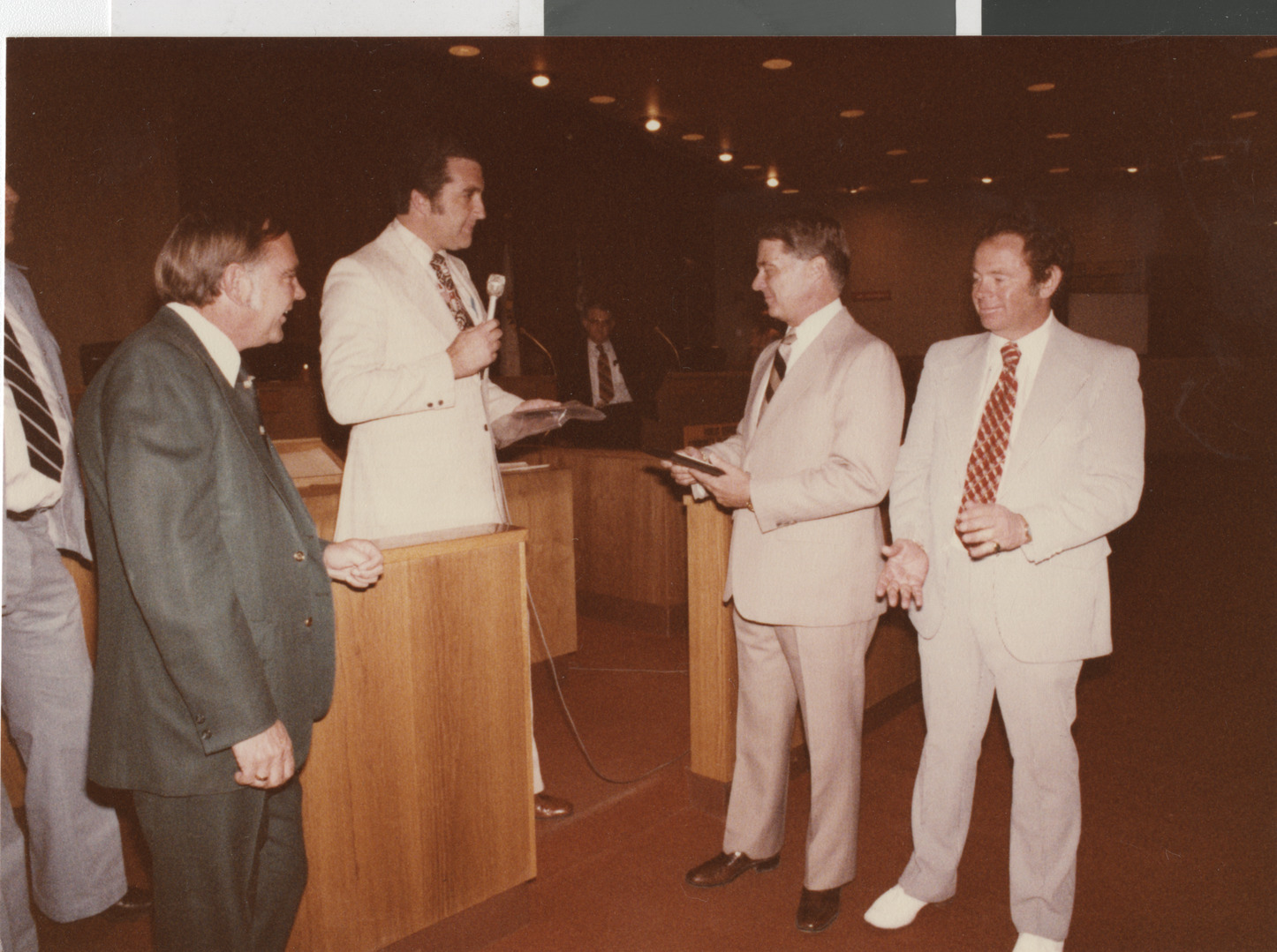 Photograph of Ron Lurie presenting a plaque in City Council chambers, circa 1978